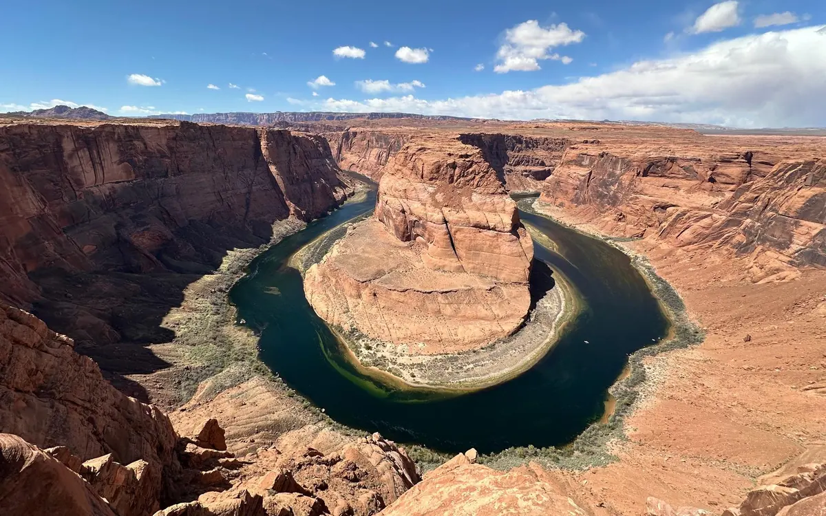 Der Colorado River, der um einen flachen roten Butte mäandert, vom Rand aus gesehen