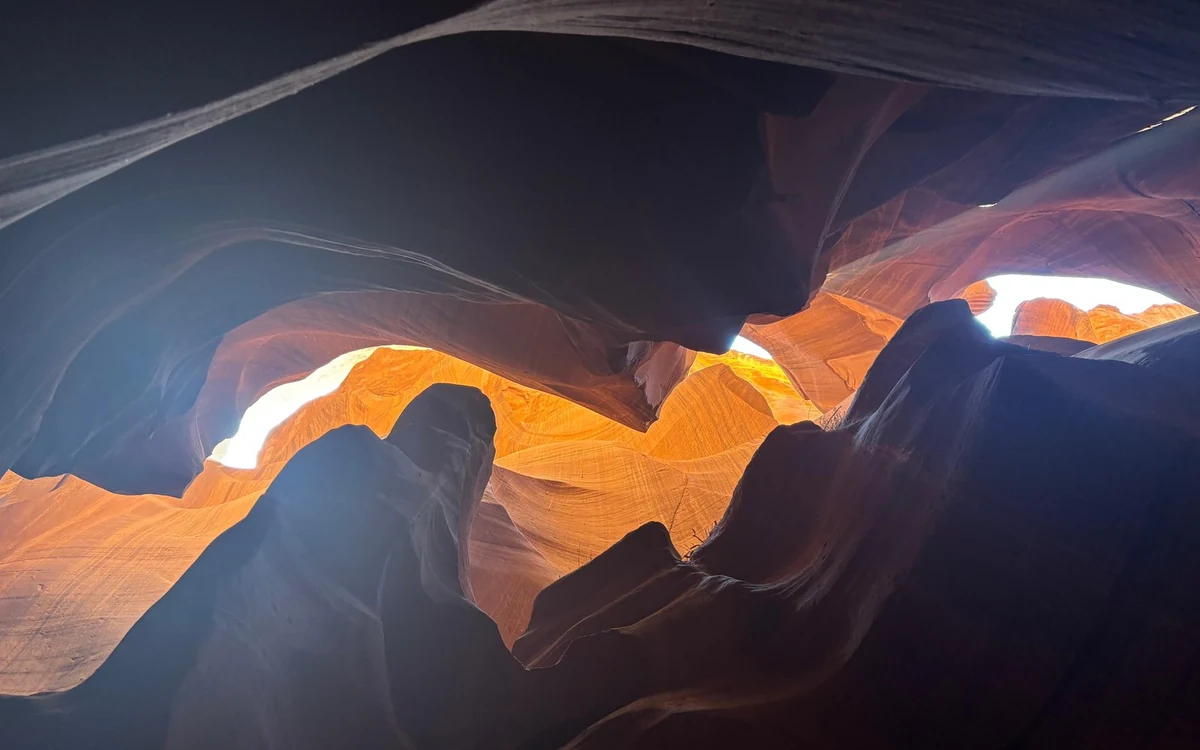 Close-up of banded sandstone, the layers curving across the frame in orange and grey