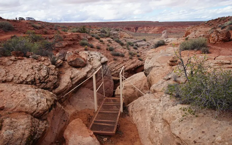 Eine Stahltreppe, die in eine schmale Lücke im Wüstenfelsen hinabführt